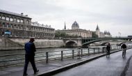 A man walks on the banks of the River Seine during 