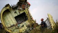 A Malaysian air crash investigator inspects the crash site of Malaysia Airlines Flight MH17, near the village of Hrabove (Grabovo) in Donetsk region, Ukraine, July 22, 2014. REUTERS/Maxim Zmeyev