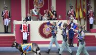 (L to R) Spain's King Felipe IV, Spain's Queen Letizia, Spain's princess Sofia, and princess Leonor watch troops and a mascot march during the Spanish National Day military parade in Madrid on October 12, 2016. / AFP / JAVIER SORIANO
