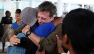 Some of the 26 Asian sailors released after being held captives by Somalia pirates for more than four years become emotional as they greet Michael Scott Moore (C), a former hostage who said that he was involved in helping with their release, as they arriv