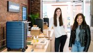 The founders with the suitcase inside their shop