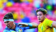 Andries Van Schalkwyk (left) of Italy is tackled by Lopeti Timani of Australia during their international rugby match at Suncorp Stadium in Brisbane, yesterday.