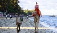 A tourist rides on camel back at the Jomo Kenyatta public beach in coastal city of Mombasa,  Kenya, March 24, 2013. Reuters / Joseph Okanga