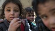 Syrian children sit in the back of a truck driven by White Helmets, as they flee their homes in the town of Beit Sawa in Syria's besieged eastern Ghouta region on March 4, 2018, following reported air strikes. AFP / Abdulmonam Eassa