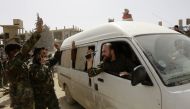 A vehicle transporting civilians and soldiers who the regime says were kidnapped by rebels and liberated in a prisoner swap arrive in a government-held area at the entrance of Harasta in Eastern Ghouta, on the outskirts of Damascus, on March 22, 2018, aft