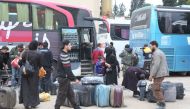 Syrian civilians are seen as the sixth convoy of vehicles carrying civilians and opposition fighters from the Damascus suburb of Eastern Ghouta arrived in the Hama province in west-central Syria on March 28, 2018.  Enes Diyab - Anadolu
