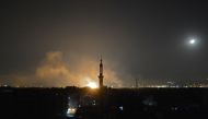 A general view shows smoke and flames rising from buildings in Yarmuk, a Palestinian refugee camp on the edge of Damascus, during overnight regime shelling on the southern district of the capital held by the Islamic State (IS) group on April 22, 2018.  AF