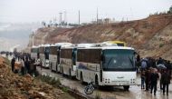 Syrians board buses prior to being evacuated from the rebel-held town of Rastan on May 7, 2018, after rebels and civilians were granted safe passage to the rebel-held town of Jarabulus, in Aleppo province, following a new deal between rebel fighters and t