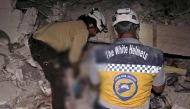 Syrian rescuers, known as White Helmets, recover bodies in Zardana, in the mostly rebel-held northern Syrian Idlib province, following air strikes in the area late on June 7, 2018.   AFP / OMAR HAJ KADOUR