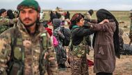 Civilians evacuated from the Islamic State (IS) group's embattled holdout of Baghouz wait at a screening area held by the US-backed Kurdish-led Syrian Democratic Forces (SDF), in the eastern Syrian province of Deir Ezzor, on February 27, 2019. AFP / Delil