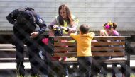 Kosovar children made crown of flowers with Kosovar police officers in the compound of the foreign detention center in the village of Vranidoll, Kosovo, on April 20, 2019. AFP / Armend NIMANI