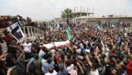 Syrians waving rebel flags and portraits of Abdelbasset al-Sarout during the funeral of the late rebel fighter in al-Dana in Syria's jihadist-controlled Idlib region, near the border with Turkey.  AFP / OMAR HAJ KADOUR