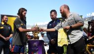 Ron Rutland (R) and James Owen (2nd L) deliver the whistle to be used in the opening Japan 2019 Rugby World Cup match to referee Nigel Owens (2nd R) at the Tokyo stadium in Tokyo on September 19, 2019, as they complete their bike expedition from Twickenha