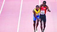 Guinea-Bissau’s Braima Suncar Dabo (right) helps Aruba’s Jonathan Busby to the finish line during the men’s 5,000m heats during the IAAF World Championships Doha 2019.