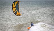 A picture taken on October 10, 2019, shows a kitesurfer riding waves at Dakhla beach in Morocco-administered Western Sahara. AFP / Fadel Senna