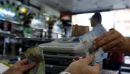 File photo : A cashier hands Syrian pounds to a customer inside a sweets shop in Damascus, Syria May 11, 2016. REUTERS/Omar Sanadiki