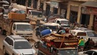 Displaced Syrian children sit in the back of a truck transporting their belongings as they pass through the town of Hazano in the northern countryside of Idlib, on February 4, 2020, fleeing northwards amid an ongoing regime offensive.  AFP / AAREF WATAD