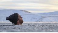 A participant baths in the waters of an ice-covered lake in southwestern Iceland during a seminar on February 1, 2020 in Kleyfarvatn, near Reykjavik. AFP / Halldor KOLBEINS