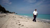 FILE PHOTO: A security agent wearing a protective mask walks on the beach amid concerns about the spread of the coronavirus disease (COVID-19), in Varadero, Cuba, April 10, 2020. Picture taken April 10, 2020. REUTERS/Alexandre Meneghini -/File Photo