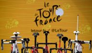 In this file photo taken on July 4, 2017, the official logo of the Tour de France is pictured behind bikes prior to the 207,5 km fourth stage of the 104th edition of the Tour de France cycling race between Mondorf-les-Bains and Vittel. / AFP / Lionel BONA