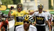 In this file photograph taken on July 29, 2018, Tour de France winner Great Britain's Geraint Thomas (L) wearing the overall leader's yellow jersey and classification third-placed Great Britain's Christopher Froome (C) react as they cross the fisnish line