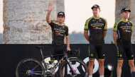 In this file photo taken on October 01, 2020 Team Mitchelton rider Great Britain's Simon Yates (L) waves on stage at the Doric Temple of Segesta, near Palermo, Sicily, during an opening ceremony of presentation of participating teams and riders, two days 