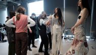 A model has her outfit adjusted backstage before a digital fashion show by a fashion design student at the Institut Francais de la Mode as part of the Women's Fashion Week in Paris, France, February 20, 2021. Picture taken February 20, 2021. REUTERS/Benoi