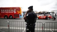 A police officer is pictured with the Bahrain Victorious team bus background after the Bahrain Victorious team bus and accommodation was searched by police yesterday (REUTERS/Benoit Tessier)