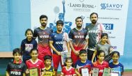 Head coach Manoj Sahibjan and officials posing for a photograph with players of NVBS who won podium spots during the LSA Open Badminton Tournament held at Middle East International School in Doha.