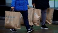 Shoppers carry bags from Primark at the start of the Boxing Day sales amid the outbreak of the coronavirus disease (COVID-19) in Manchester, Britain, December 26, 2020. REUTERS/Phil Noble/File Photo