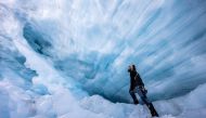 Glaciologist Martin Stocker-Waldhuber, from the Austrian Academy of Sciences, explores a natural glacier cavity of the Jamtalferner glacier near Galtuer, Austria, October 15, 2021. Giant ice caves have appeared in glaciers accelerating the melting process