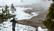 A Yellowstone Expeditions guide carries skis near Violet Springs. Photo for The Washington Post by Dina Mishev
