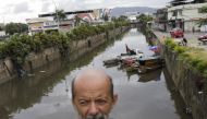 Luiz Bispo, who is living at Pavuna River which flows to Guanabara Bay, stands near his floating house what he says is an artistic installation developed by him to bring joy to the region and awareness to pollution of its waters, in Rio de Janeiro, Brazil March 21, 2022. Picture taken March 21, 2022. REUTERS/Ricardo Moraes
