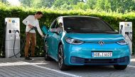 A man charges an electric ID. 3 car during a media event at German carmaker Volkswagen's so-called glass manufactory in Dresden, Germany, June 8, 2021. REUTERS/Matthias Rietschel/File Photo