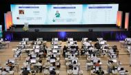 Staff members sit at computers as screens show an official quick-count of the national election at a command center of the Parish Pastoral Council for Responsible Voting (PPCRV), the election watchdog organization in Manila, Philippines, May 9, 2022. REUTERS/Willy Kurniawan