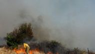 File photo: Firefighters working to extinguish a wildfire in Spain. Pic by: Borja Suarez / Reuters