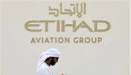 A visitor walks past the Etihad Aviation Group logo on display during the fifth day of Dubai Air Show in Dubai, United Arab Emirates, November 21, 2019. (REUTERS/Christopher Pike)