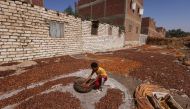 Mohamed, 13 years old, helps his father Fathy Kazzaz to spread dates on sheets and leaves them under sunlight during the harvest season at Dahshour village, south of Giza governorate, Egypt October 4, 2022. (REUTERS/Amr Abdallah Dalsh)