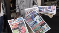 A man sells Senegalese newspapers with headlines of footballer, Sadio Mane's knee injury in Dakar on November 10, 2022. (AFP/John Wessels)