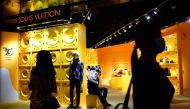 Customers wearing face masks following the COVID-19 outbreak walk past a store of French luxury brand Louis Vuitton inside a shopping mall in Beijing, China September 19, 2020. REUTERS/Tingshu Wang/File Photo/File Photo