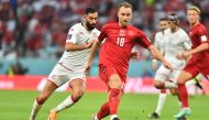 Denmark's Christian Eriksen is pursued by Tunisia's Yassine Meriah. Pic: Abdul Basit