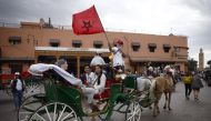 A man on a horse drawn carriage waves a Morocco flag in Marrakech ahead of the France versus Morocco semi-final match on December 14, 2022.  REUTERS/Juan Medina
 