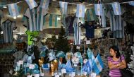 A woman walks inside a store in the eve of the Qatar 2022 World Cup final match between Argentina and France in Buenos Aires, on December 16, 2022. (Photo by Luis ROBAYO / AFP)