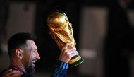 Argentina's captain and forward Lionel Messi holds the FIFA World Cup Trophy upon arrival at Ezeiza International Airport after winning the Qatar 2022 World Cup tournament in Ezeiza, Buenos Aires province, Argentina on December 20, 2022. (Photo by Luis ROBAYO / AFP)