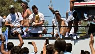 Argentina's Lionel Messi waves at fans holding the FIFA World Cup Trophy as the team parades on board a bus after winning the Qatar 2022 World Cup tournament in Buenos Aires, Argentina on December 20, 2022.  (Photo by Luis ROBAYO / AFP)
 