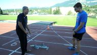 In this file photo taken on July 15, 2014 French triple European sprint champion Christophe Lemaitre (R) speaks with his coach Pierre Carraz during a training session in a stadium at the French eastern city Aix-les-Bains. Photo by JEAN-PIERRE CLATOT / AFP