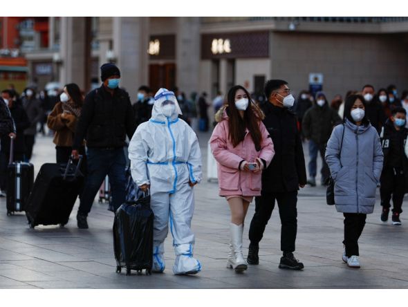 A traveller wearing a protective suit walks outside Beijing Railway Station as the annual Spring Festival travel rush starts, amid the coronavirus disease (COVID-19), ahead of the Chinese Lunar New Year, in Beijing, China, on January 7, 2023. REUTERS/Tingshu Wang