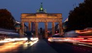 Car traffic makes its way on a road in front of the illuminated Brandenburg Gate, in central Berlin, Germany, November 15, 2022. REUTERS/Lisi Niesner/File Photo