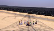 Employees walk at Al Dhafra Solar Photovoltaic (PV) Independent Power Producer (IPP) project, in the United Arab Emirates' capital Abu Dhabi, during a visit by the French economy minister on January 31, 2023. (Photo by Karim Sahib / AFP)