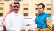 Al Uqda Complex Manager Abdulaziz Jassim Al Boenain presents the trophy to Ronan Thomas.